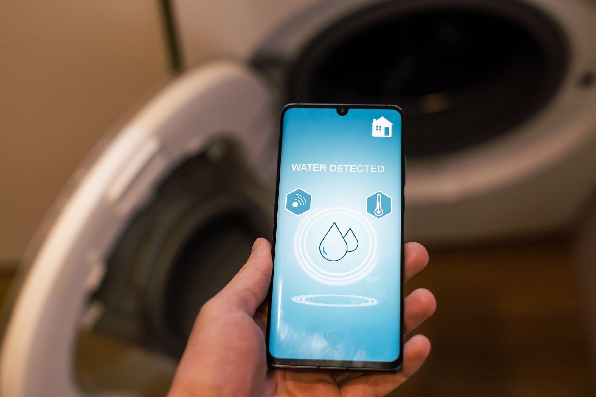 smartphone showing water detection notification in appliance recognized by wireless sensor